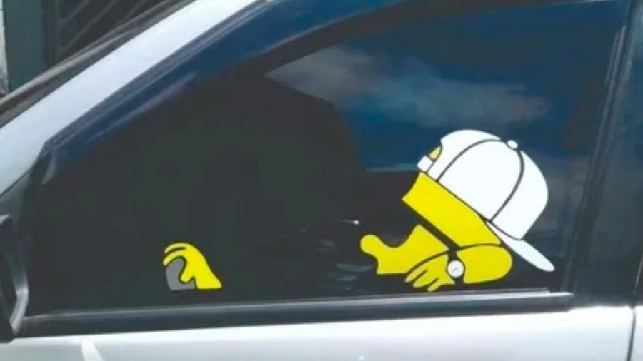 Adesivo 'faz de conta' que personagens como Bart Simpson estão ao volante ou no banco do carona; item é proibido e traz risco Adesivo 'faz de conta' que personagens como Bart Simpson estão ao volante ou no banco do carona; item é proibido e traz risco