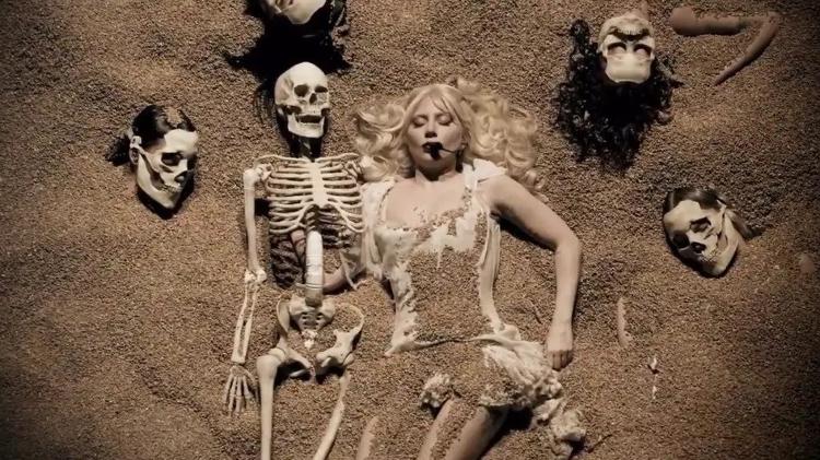 "Enterrada", Gaga usa peruca loira e vestido curto de renda branca quando performou músicas como "Perfect Celebrity", "Disease" e "Alejandro"; traje também traz referência ao clipe de "Bad Romance" "Enterrada", Gaga usa peruca loira e vestido curto de renda branca quando performou músicas como "Perfect Celebrity", "Disease" e "Alejandro"; traje também traz referência ao clipe de "Bad Romance"